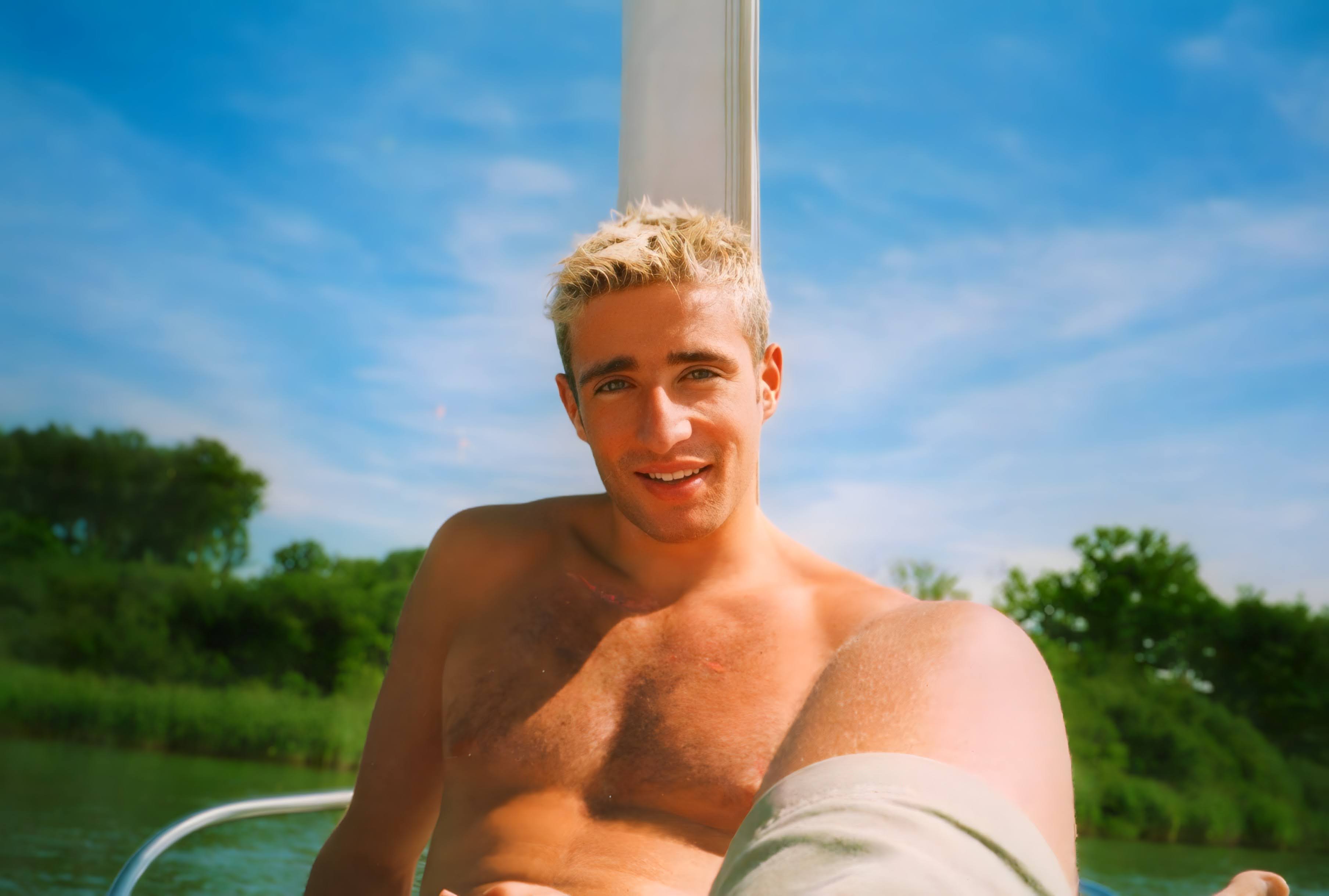 Angel mit blonden Haaren am See im Sommer