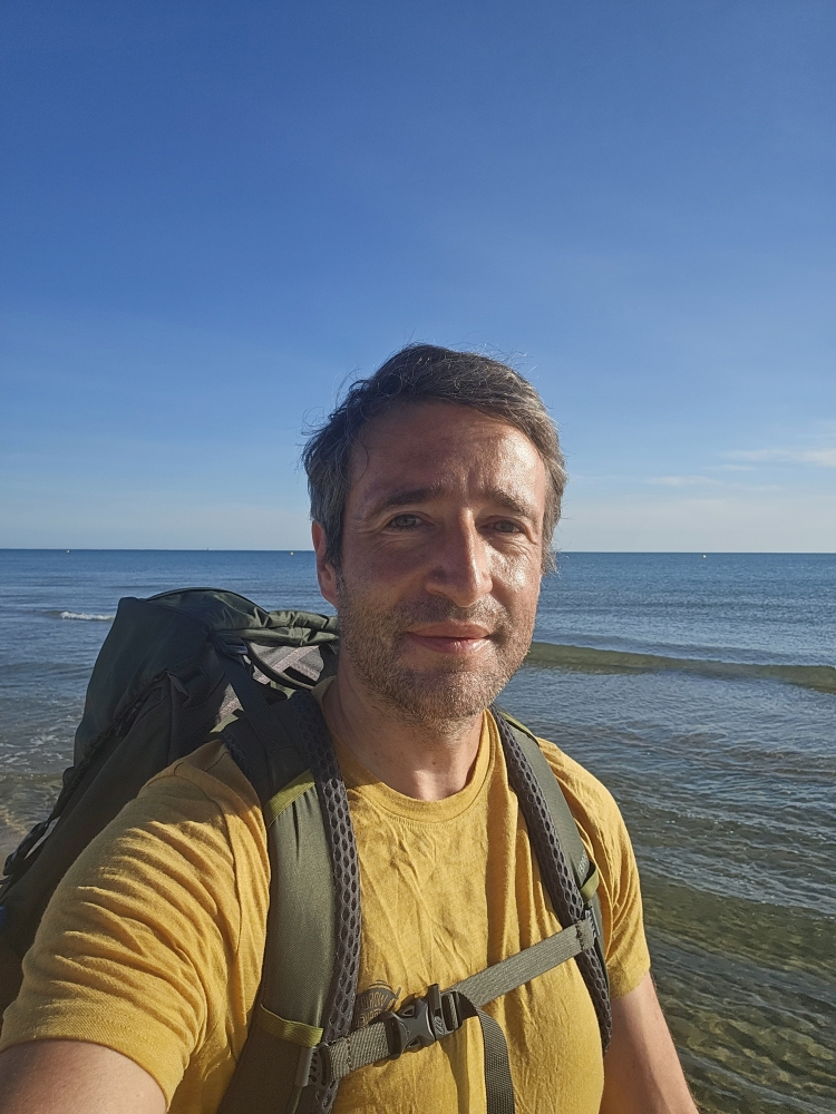 Angel Selfie am Strand, gelbes Shirt, Rucksack, Mittelmeer